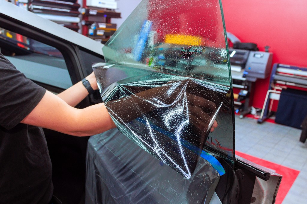 Technician applying ceramic window tint to a vehicle